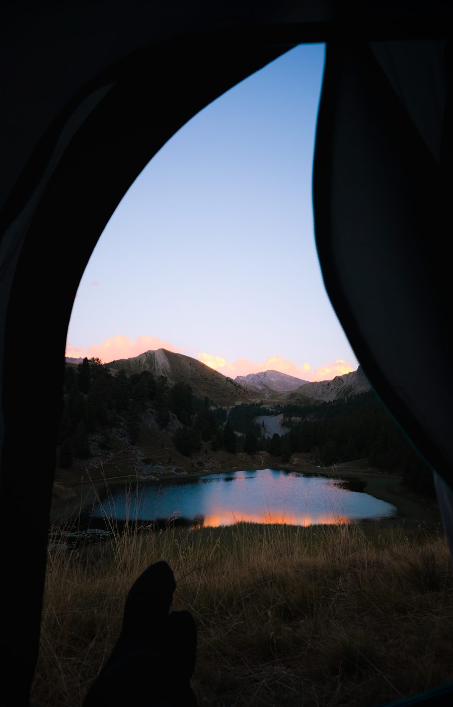 Mountain lake seen from a tent at dawn